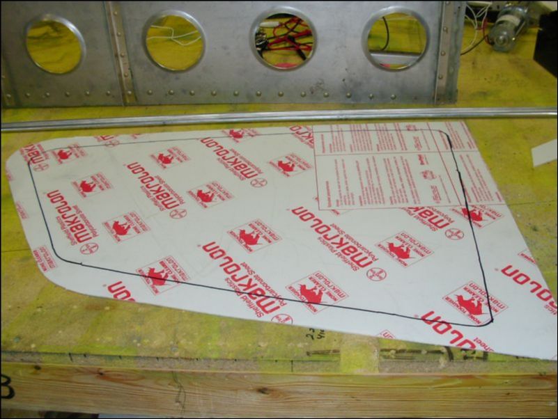 Have a helper hold the window in place inside the cabin then mark the window area from outside.