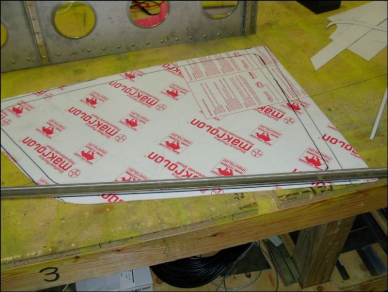 Lay an upholstery channel on the marks made in the last step and mark the window at the outside of the channel.  Cut the window on the outside marks.