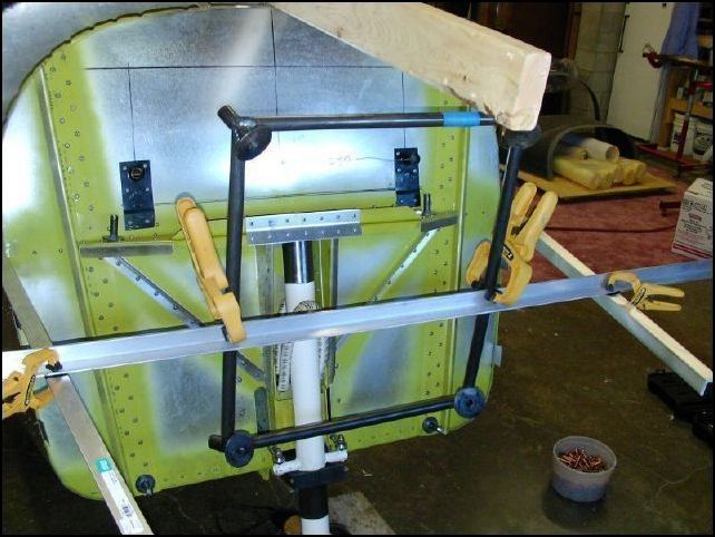 Put a 2x4 on the top of the firewall and instrument panel.  This shows me the angle of the cowling so that I can position the engine mount as high as possible but still be sure to clear the cowling.  Then I clamped the engine mount to the center L for a rough idea of where I want the finished mount to be located.