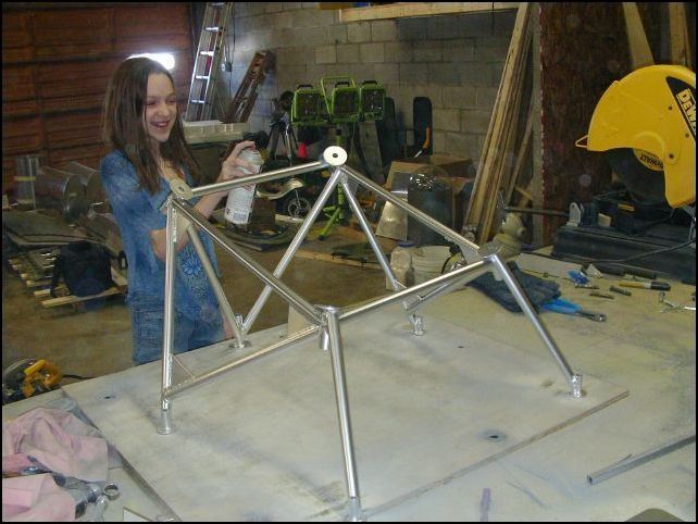 Grinded a few rough spots of weld off, then clean and painted with high-temp paint.  This image shows my daughter Tiffany finishing up the paint job.