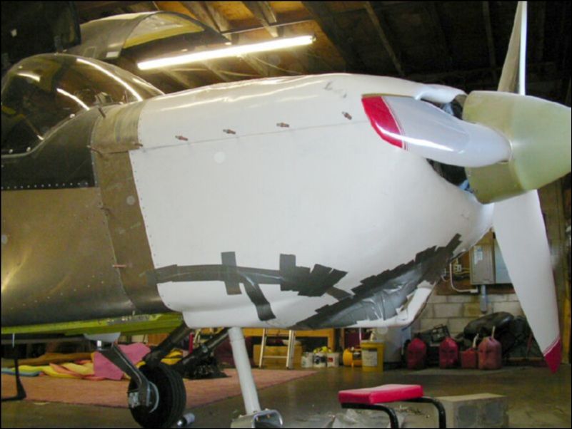 Reinstall the cowling.  Cut and fit the rest of the lower cowling.  Join the parts together with aluminum strips and rivets then seal the joints with tape so that the resin will not leak out when applied.