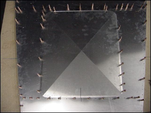 This image shows the access door lined up on the bottom skin.  Notice that the access door is NOT wide enough to be able to install screws through it and into rivnuts that would have been installed in the Z angles.  So again, I guess the rivnuts will have to be installed in the skin instead.  By the way, aircraft spruce sells a nice little rivnut tool that you just screw into the rivnut and then pull it with your rivet gun just like any other rivet.  WORKS GREAT!  Purchase a couple of them though, I broke one by pulling too hard <grin>