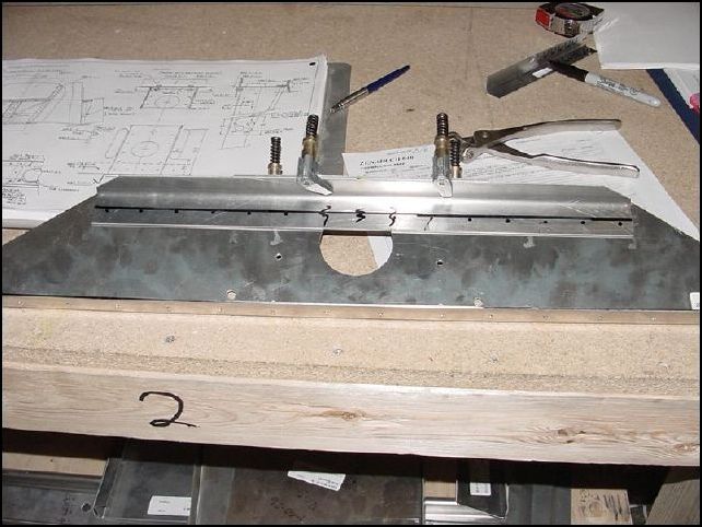 Mark center of 20-F-16-11 (forward gusset) and 20-F-16-10 (upper angle).  Clamp in position on 20-F-16-1.  Drill and cleco in place.  NOTE:  Do not drill last hole on each end, be sure not to drill where the gear angle bolt holes will be.  Only drill up to 150 mm in from each side on 20-F-16-10.