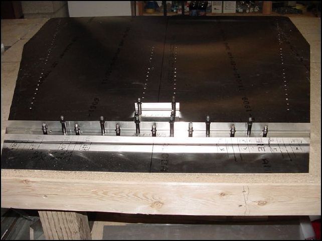 This image shows the forward floor channel and center bearing channel clecoed to the cabin floor.