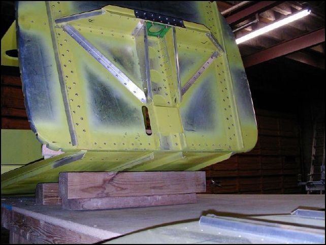 Position and rivet the firewall to the front of the cabin floor.