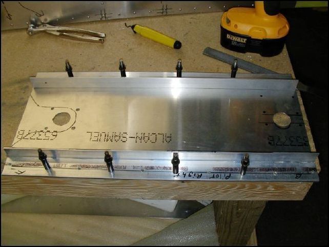 This is the new center seat panel drilled for my new fuel selector.  It also has the right pilot seat rail and left co-pilot seat rail clecoed in place.