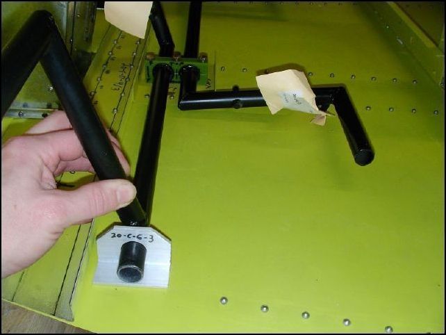 Slide 20-C-6-3 (outboard pedal bearing) on to the rudder pedals.  Drill into place on floor.  NOTE:  the holes must be centered to the bottom longerons and the bearing must be in parallel to each other so that the pedals will fit the bearings.  