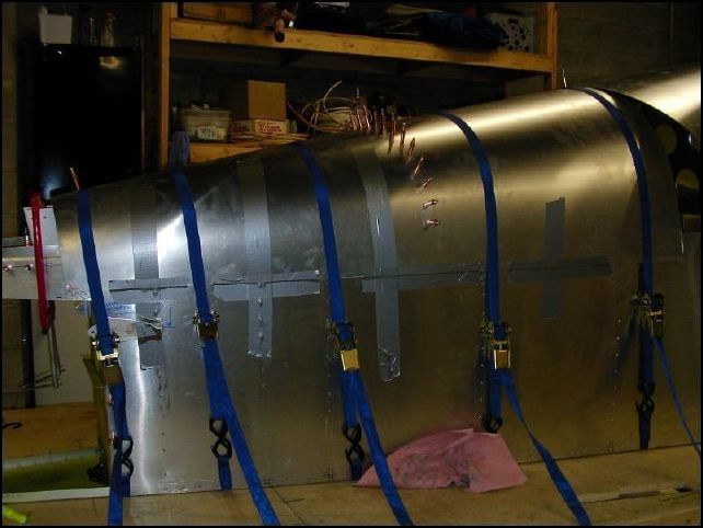 Yes, that is duct tape you see in this picture.  It was the easiest way I could think of the make sure that the skin was held in place.  Now I drilled the top center holes in the next top skin for bulkheads 5 and 4 but NOT 3 at this time.  I then drilled the top center hole in bulkhead 4 and clecoed the skin to that bulkhead and bulkhead 5 overlapping the rear top skin by 20 mm.