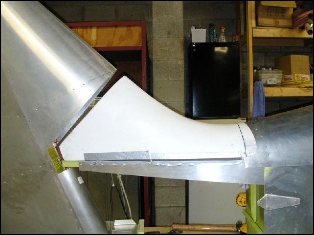 I have to do some work on the tail saddle.  Yes, it will go UNDER the top fuselage skin when it is installed.  I don't like the HUGE gap between the saddle and the rudder so I am going to do some glass work before installing the saddle.