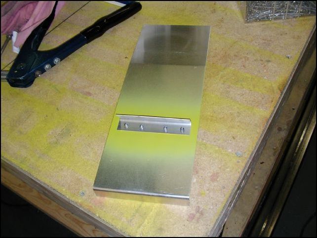 Rivet L angle to top of torque tunnel cover.