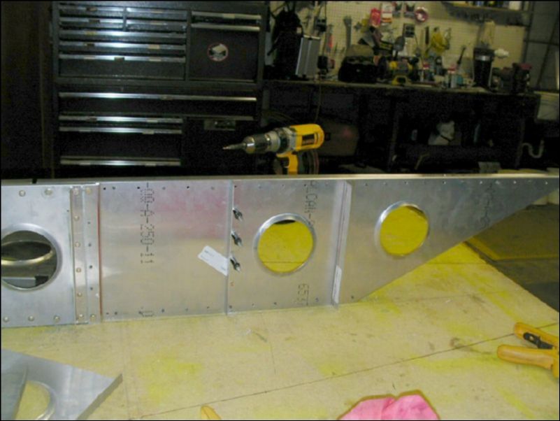 Drill the four rivet holes through the wing tip extension into the spar web.