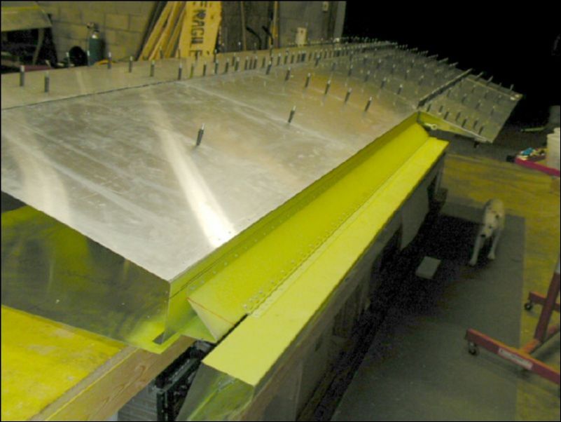 Deburr, clean, prime, and rivet the aileron hinge to the aileron support channel.