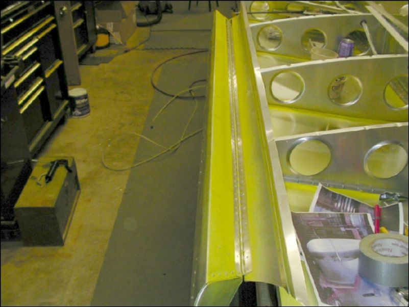 Deburr, clean, prime, and rivet the aileron hinge to the aileron support channel.